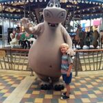 A boy is standing next to a hippo on Royal Caribbean