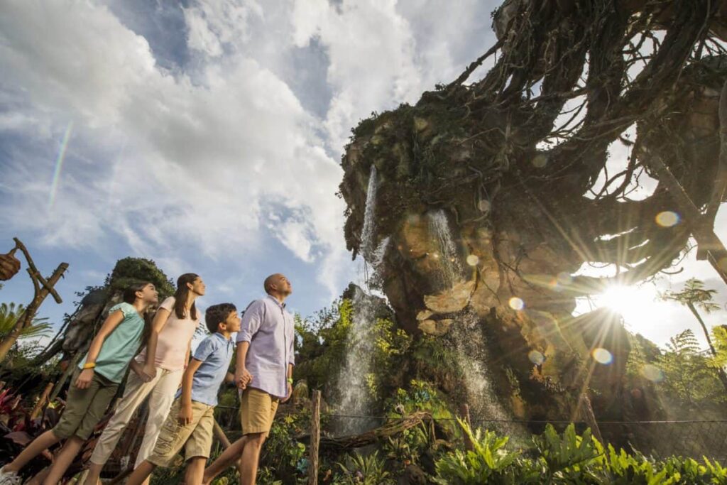 A family is standing in front of a waterfall at Disney's