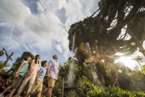 A family is standing in front of a waterfall at Disney's